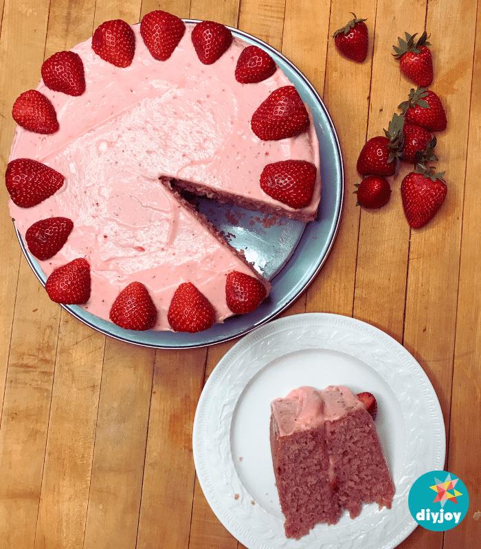 Extremely strawberry cake, a moist pink layer cake with strawberry cream cheese frosting and fresh berries