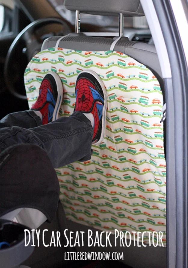 Quilted seat back cover printed with small cars hangs over a front seat, with a child's legs and sneakers resting on it
