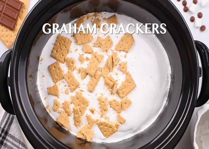 Adding the topping to the slow cooker s'mores cake