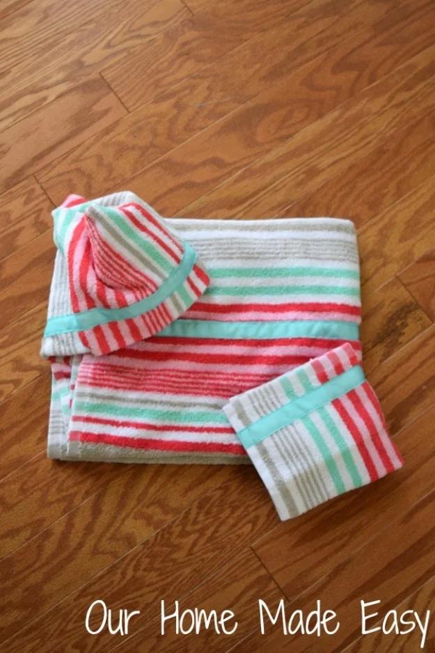 A white hooded baby towel trimmed in yellow bias binding, folded on a nursery chair, one of the things to sew and sell.
