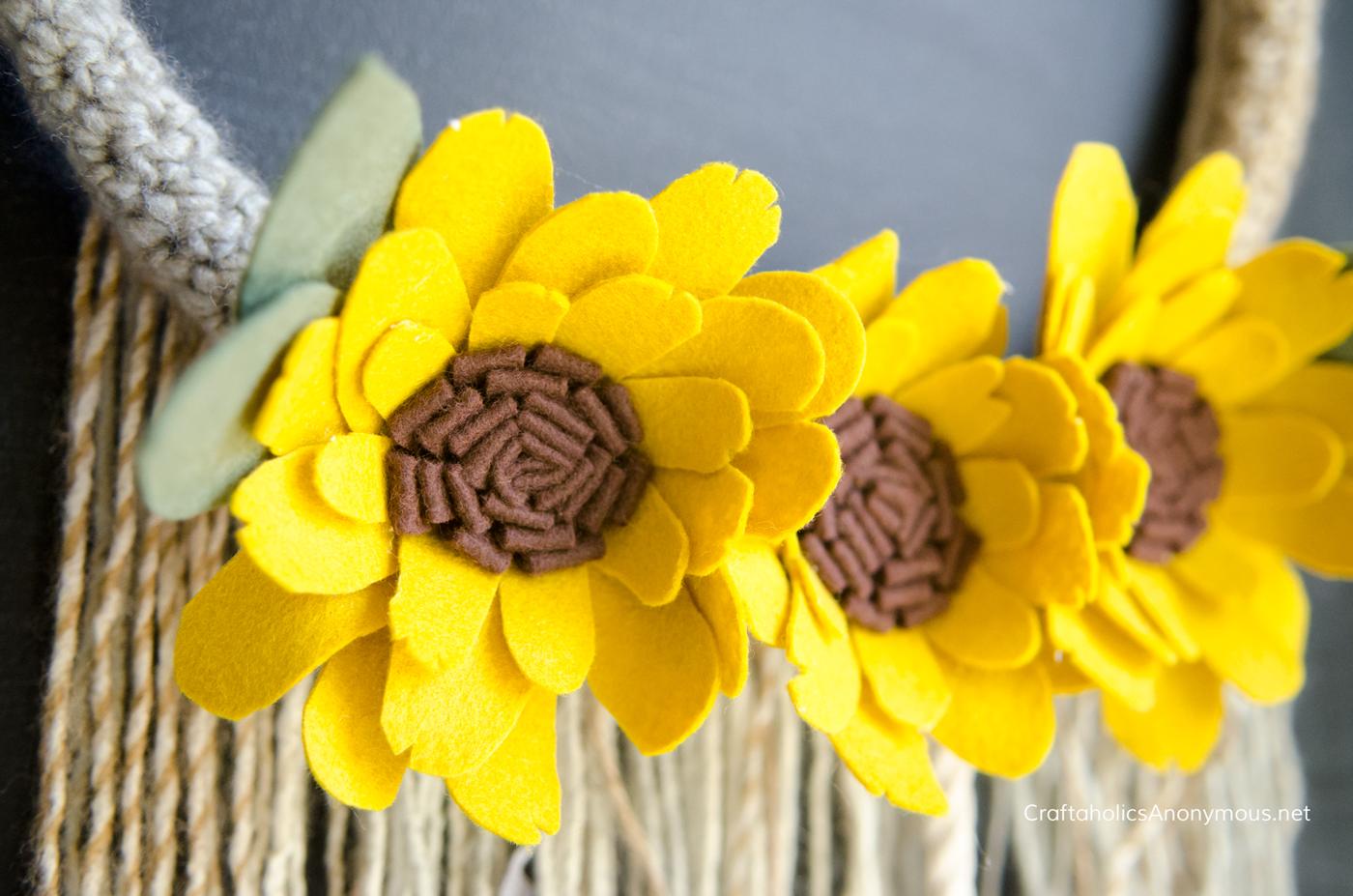 Sunflower wreath with faux blooms massed tightly across the form, a sunny fall wreath for a front door