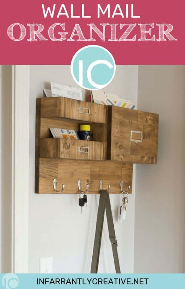 Stained wood wall organizer with two stacked mail boxes, a wide file section, metal label plates and four hooks below