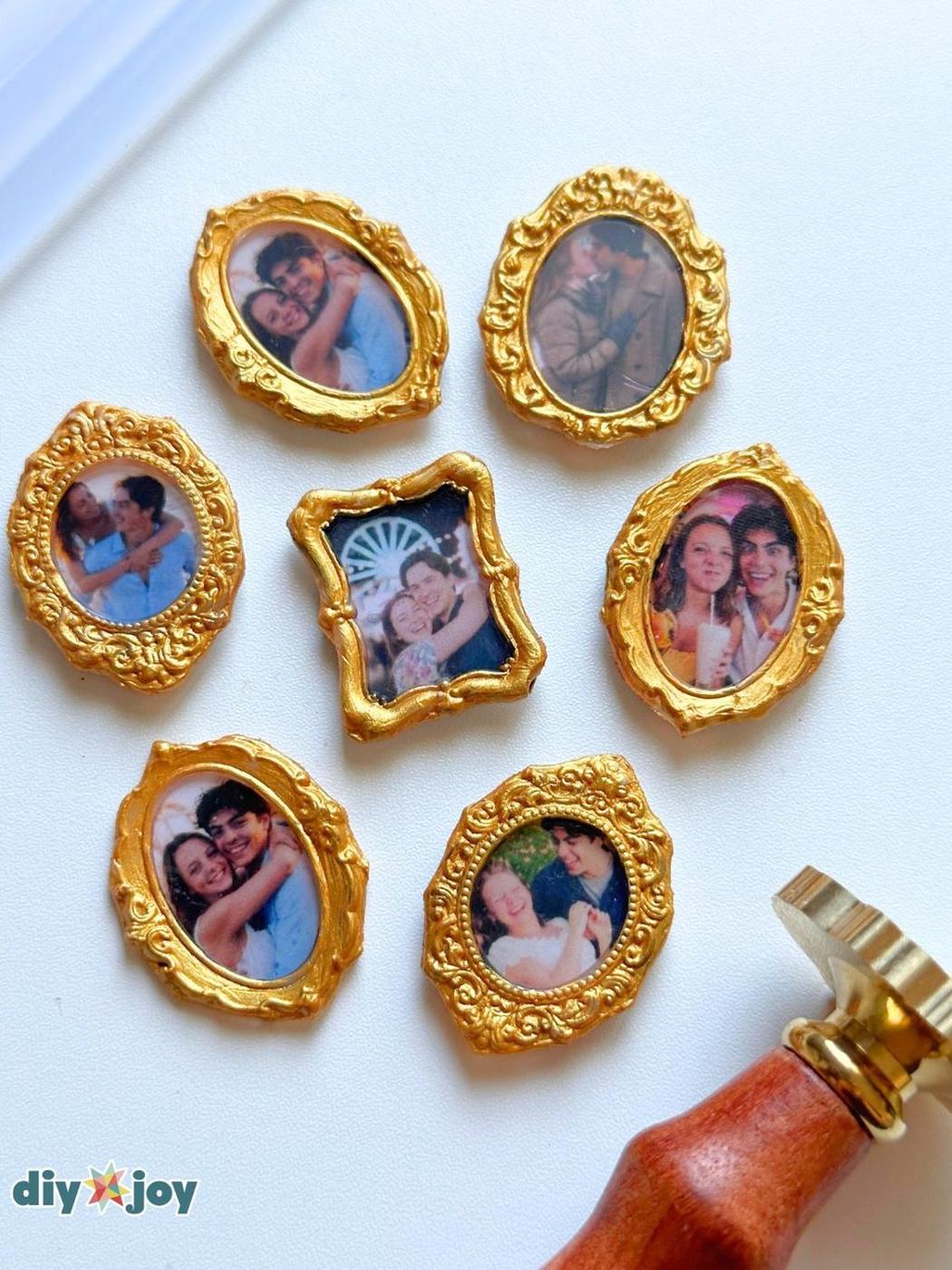 Six small gold ornate photo frame magnets with family photos inside, scattered on white with pink felt flowers