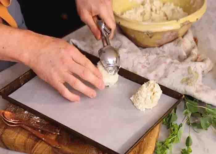 Scooping mounds of drop biscuit into the baking sheet