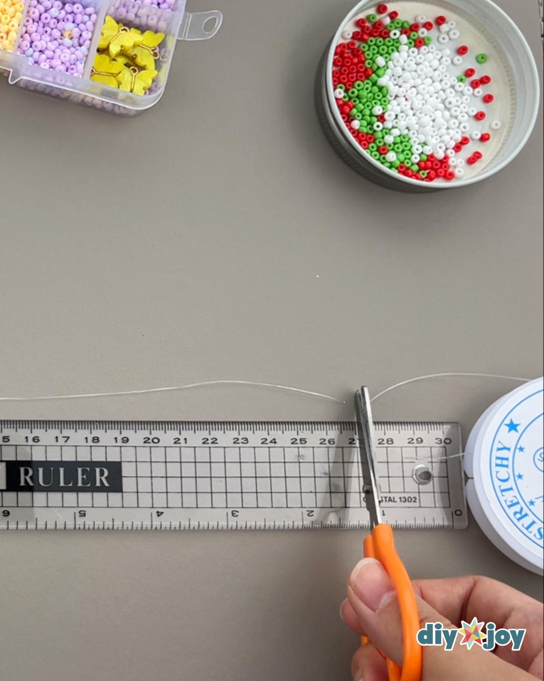 Homemade Cherry Bracelet — cutting the nylon