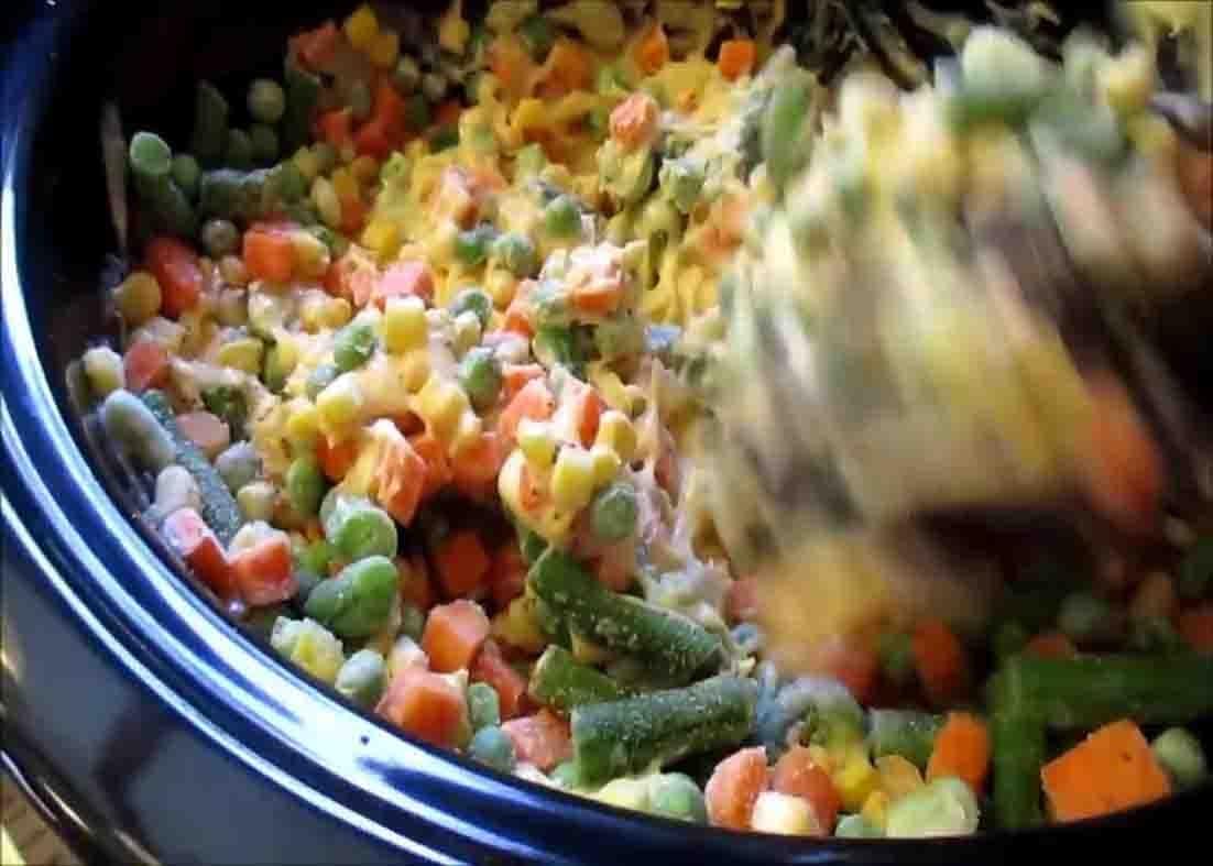 Mixing all the ingredients of the slow cooker chicken pot pie