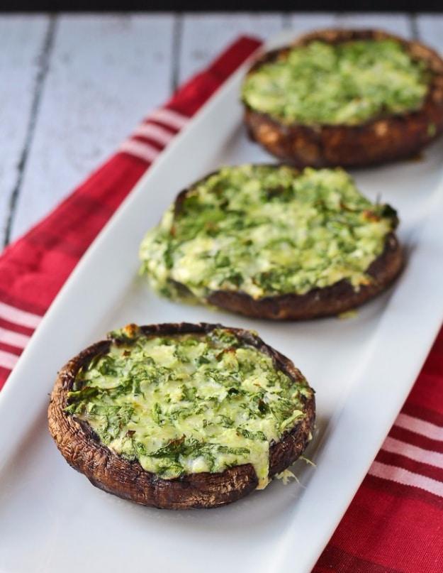 Grilled portobello mushrooms stuffed with spinach and melted cheese, marked from the grill grate for an outdoor barbecue