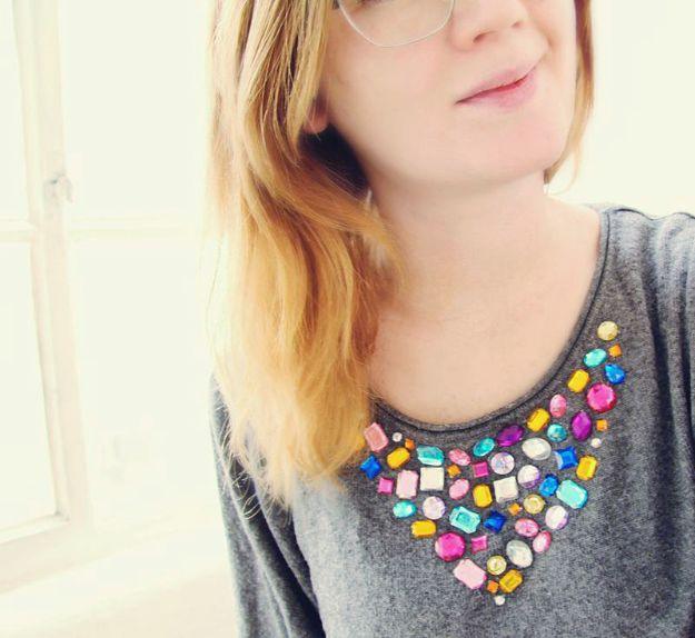 Gray marl sweater with a collar of multicolored jewel shapes glued around the neckline in a bib shape