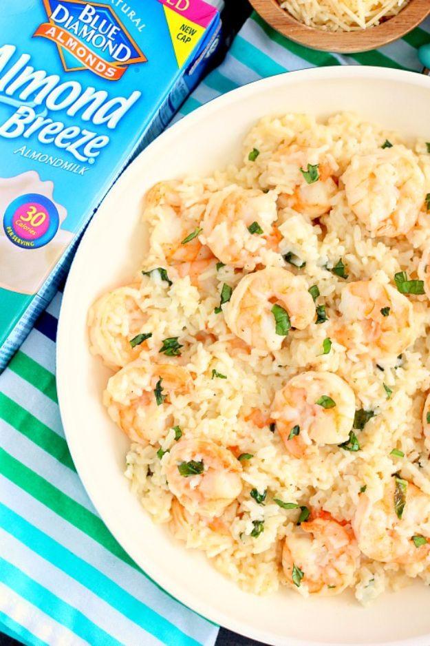 Parmesan basil shrimp and rice in a white bowl on a striped towel, creamy rice with shrimp and chopped basil