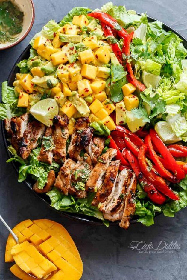 Cilantro lime chicken salad on a dark platter with sliced grilled chicken, mango, avocado and red pepper
