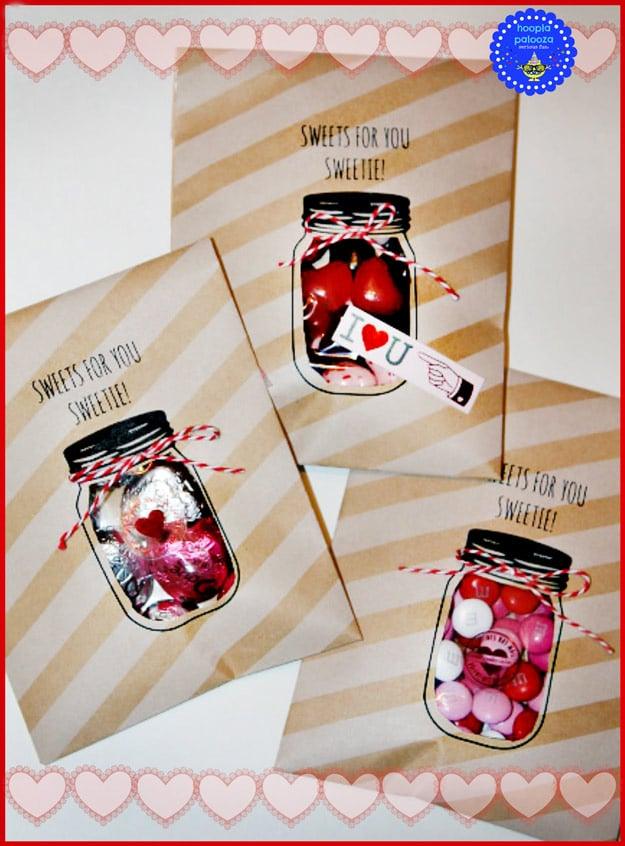 Paper treat bags cut in the shape of mason jars filled with candy for a Valentine's Day classroom party