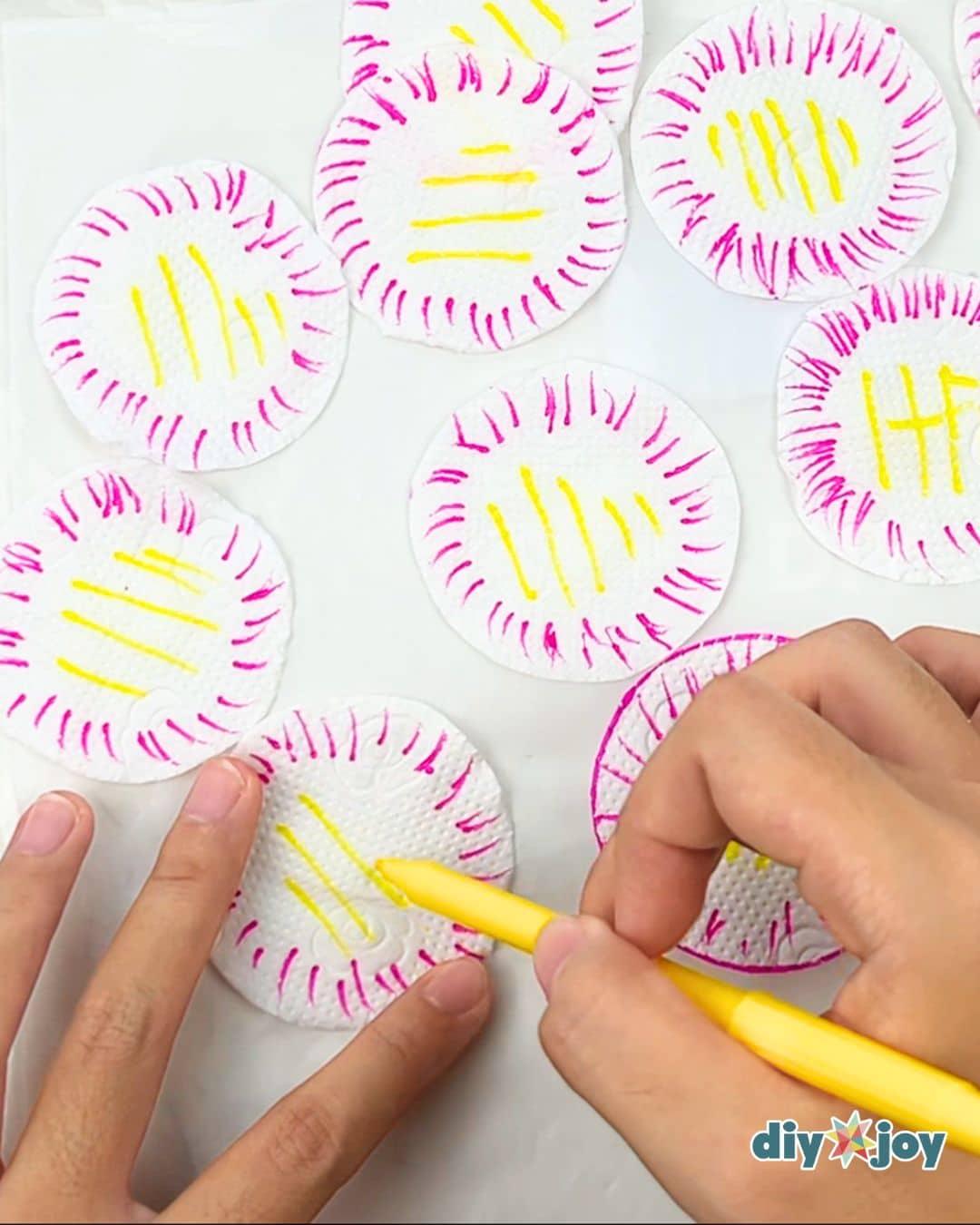 Coloring step for homemade paper flowers, a felt tip marker adding color to the edges of tissue petals