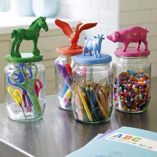 Animal topped mason jars organizing kids supplies, four painted plastic animals glued to jar lids holding scissors and beads