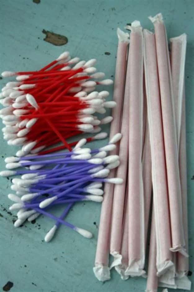 Cupid's arrow game with children shooting Q-tips through wide milkshake straws at a bowl on a blanket