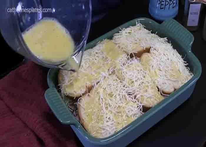 Adding the egg mixture over the monte cristo breakfast casserole