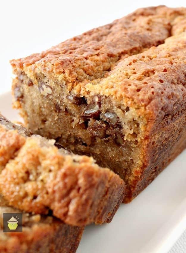 Coffee pecan pound cake loaf cut into thick slices showing pecan pieces through the crumb on a white plate
