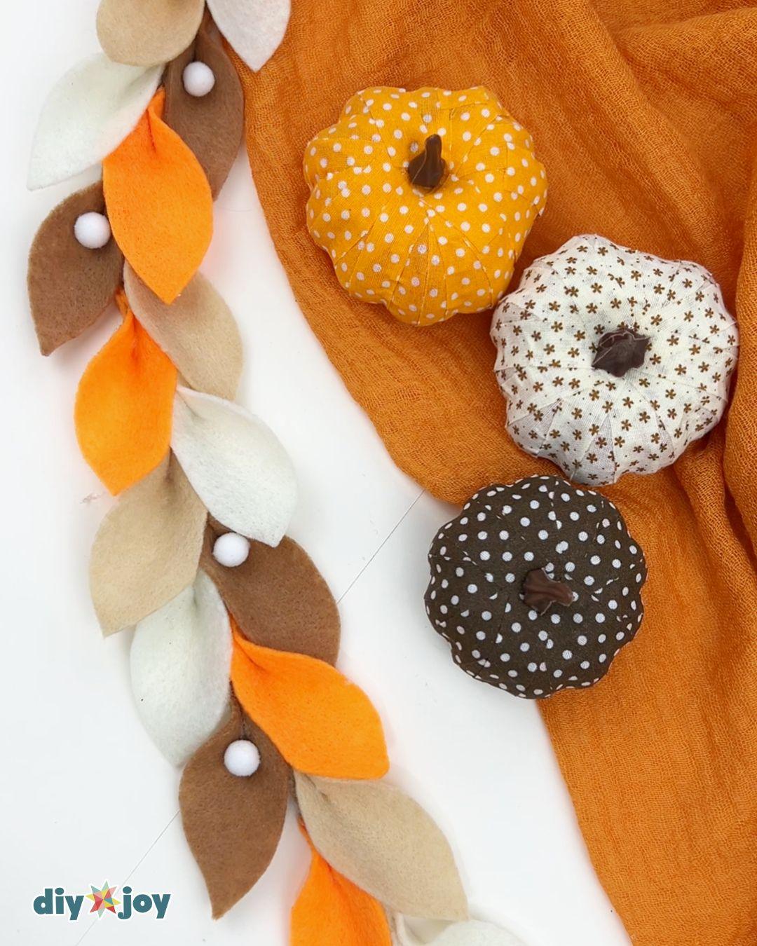 Fall decorations DIY: a felt leaf garland with rope and pom-poms for a fireplace mantel or staircase.