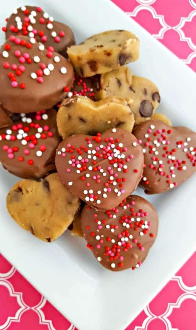 Chocolate covered cookie dough hearts, chocolate coated hearts with sprinkles and plain dough hearts on a plate