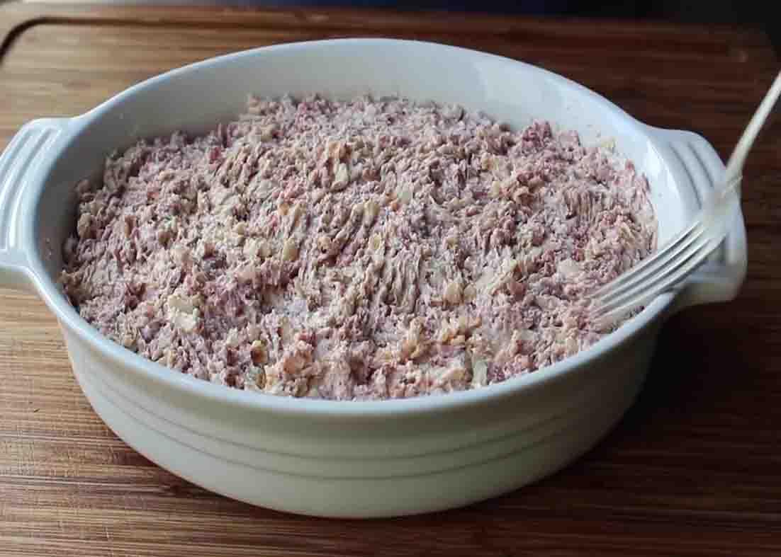 Assembling the baked reuben dip in the baking dish