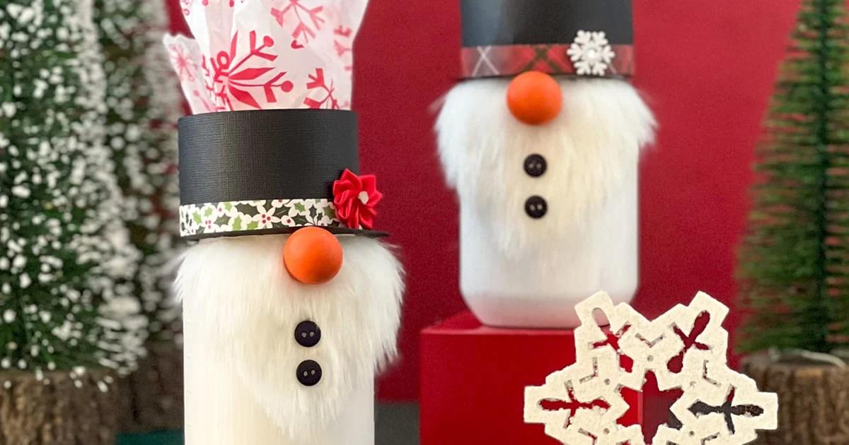 White painted mason jar decorated as a snowman gnome with a faux fur beard, paper hat and small carrot nose
