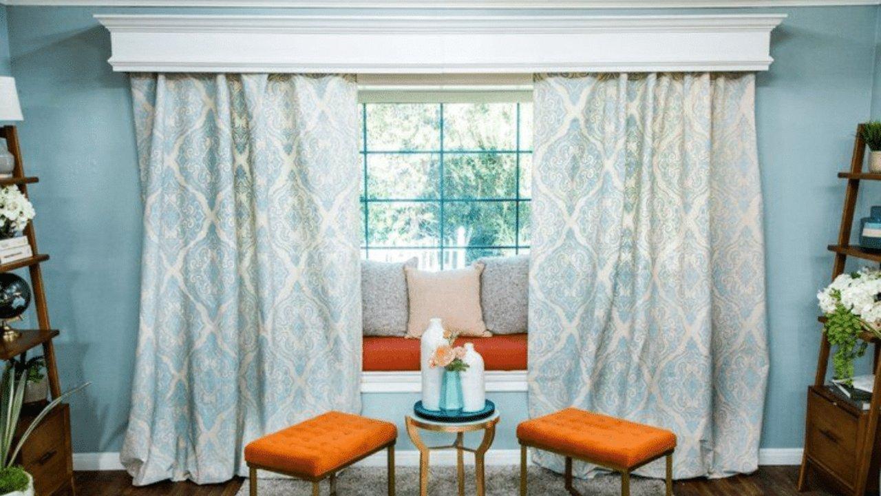 DIY stenciled drapes made from a drop cloth painted with a large repeating pattern, hung from a wooden rod