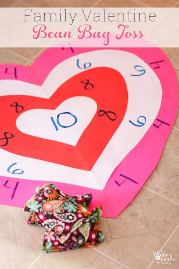 Valentine's bean bag toss game board made from pink and red poster board hearts with bean bags on the floor