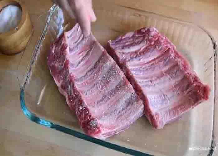 Seasoning the ribs before slow-baking in the oven