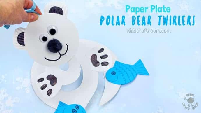 White paper plate polar bear twirler with black paw pads and blue paper fish, cut in a hanging spiral