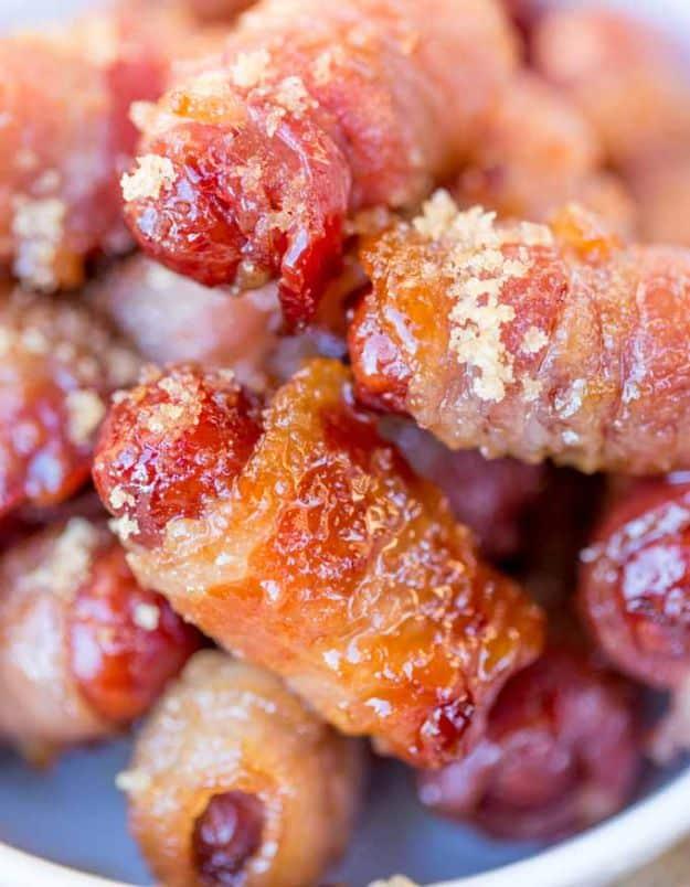Bacon brown sugar smokies, bacon wrapped cocktail sausages coated in melted brown sugar glaze piled on a plate