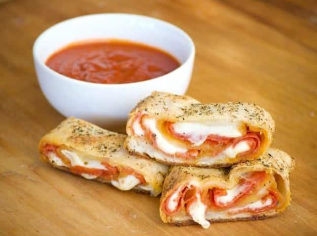 Pepperoni bread sliced into spirals of pepperoni and melted provolone, served with a bowl of marinara sauce