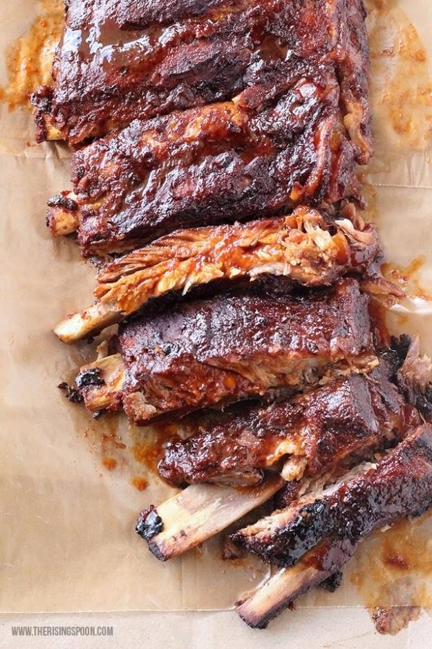 Crock pot BBQ ribs standing on edge in a slow cooker, coated in dry rub and barbecue sauce at a backyard cookout