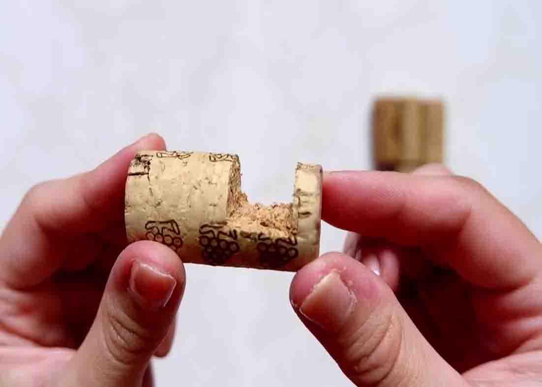 Carving out a portion in the wine cork for the bottom of the DIY mobile holder