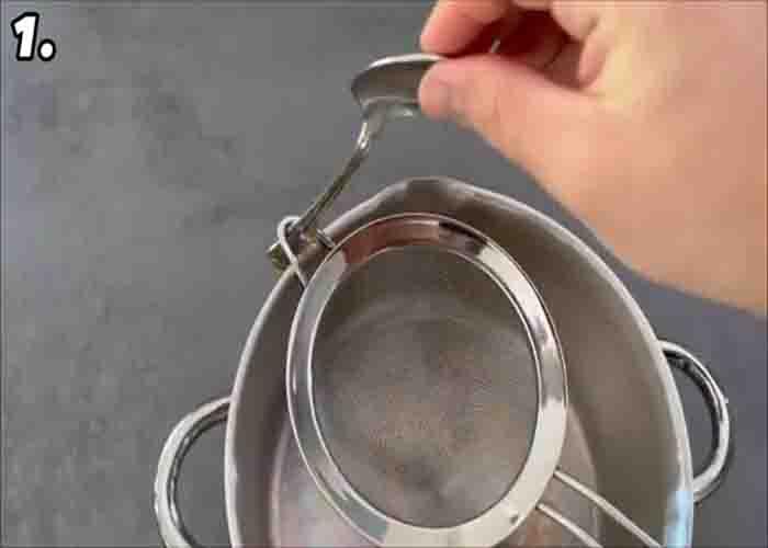 Securing a colander over a pot by using a spoon