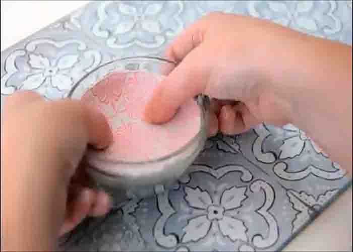 Pressing the clay into the glass bowl to shape the clay bowl
