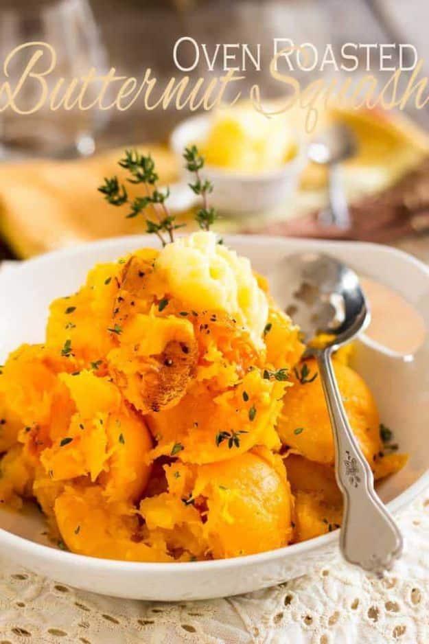 Roasted butternut squash scooped into soft pieces in a white bowl with melting butter, thyme and a spoon