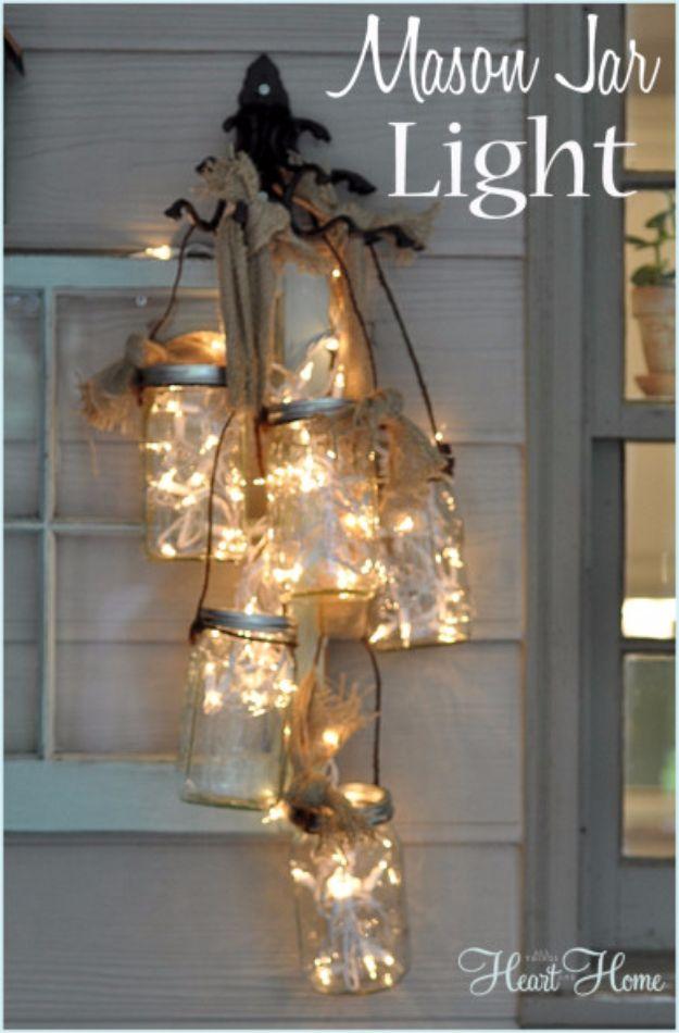 Pin graphic reading Mason Jar Light showing a cluster of jars full of fairy lights hanging on a porch wall