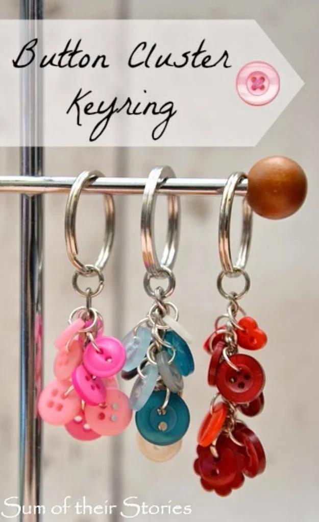 Button cluster key ring, three keyrings hanging on a rail with clusters of small pink blue and red buttons on chains