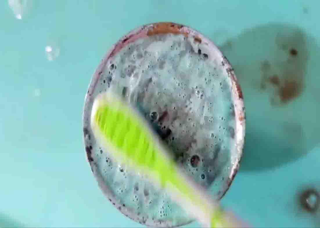 Brushing the clogged shower head