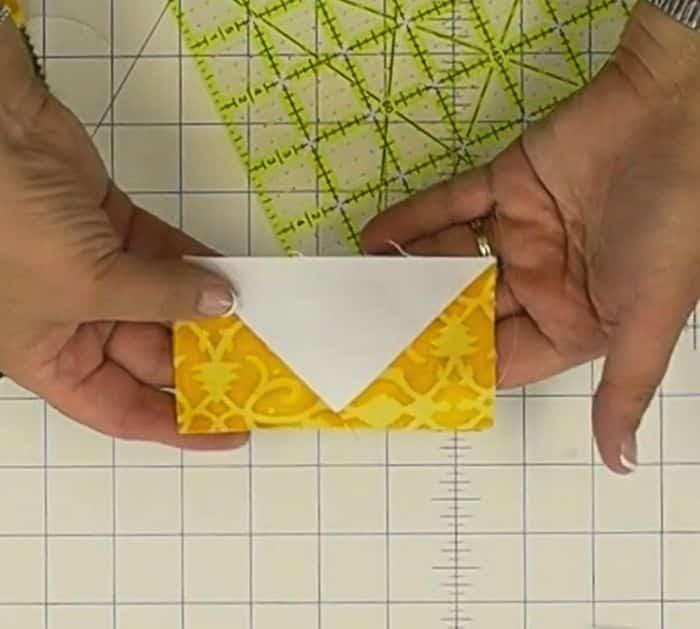 hands holding a flying geese block