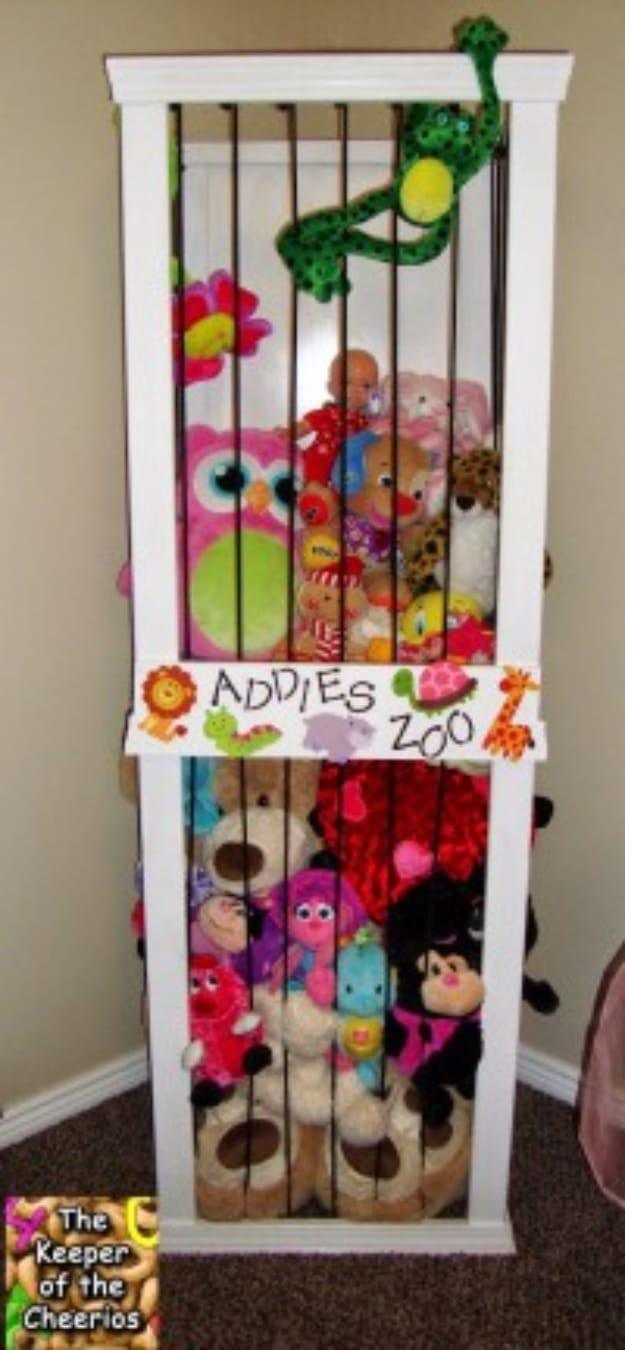Stuffed animal storage zoo, a tall white frame strung with black bungee cords holding plush toys behind a painted zoo sign