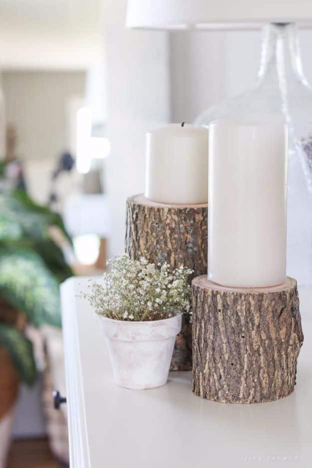 A firewood log bored with holes for lit tealights, running down the middle of a table as primitive country decor