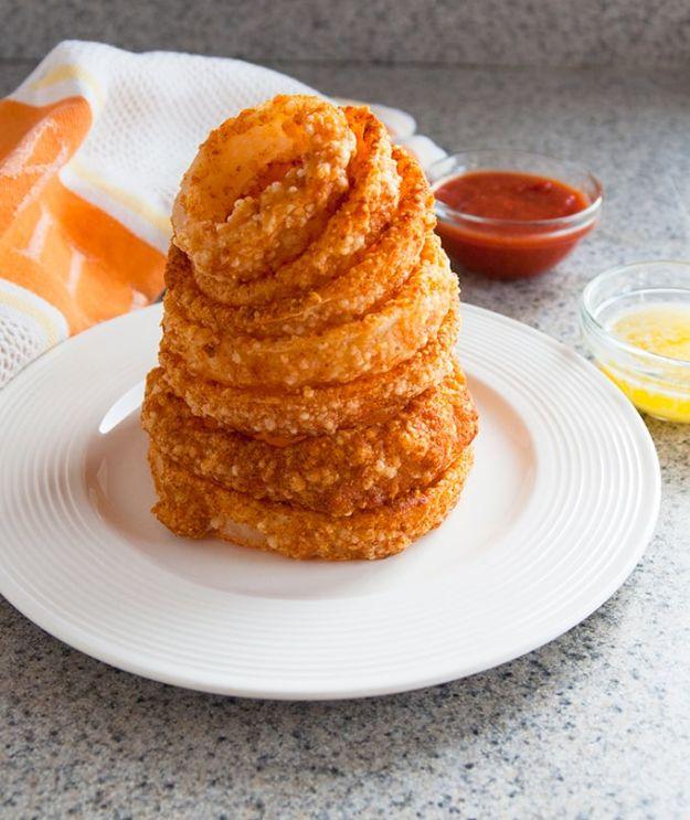 Baked parmesan gluten free onion rings on a sheet pan, crisp and golden, served with marinara for dipping