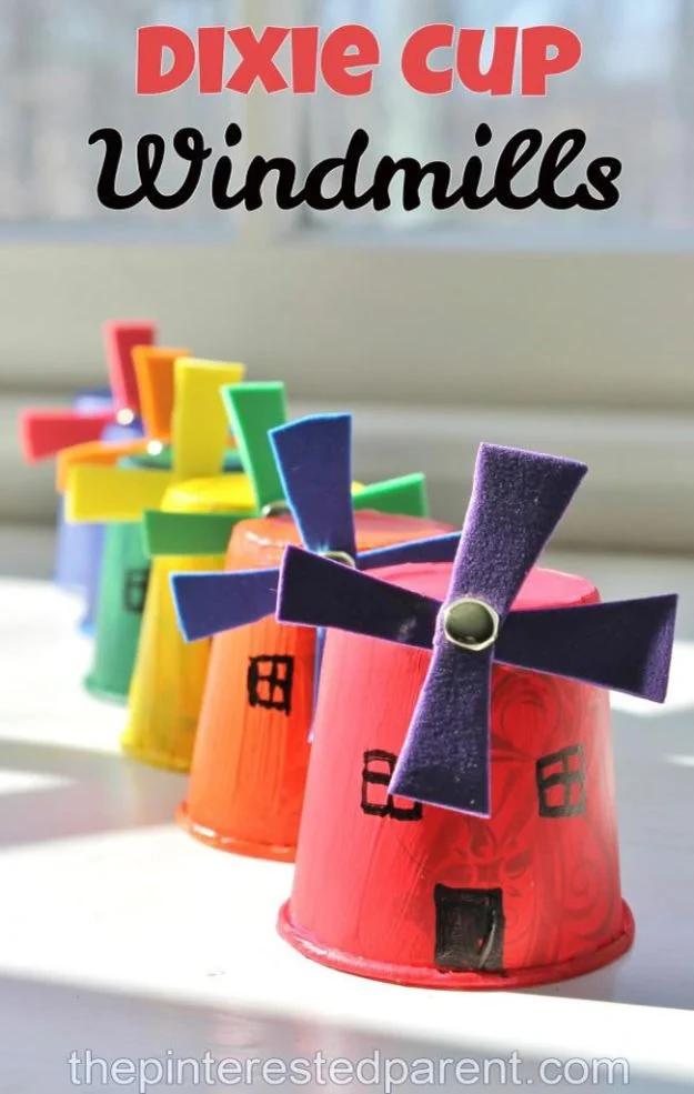 Row of five paper cup windmills in red, orange, yellow, green and blue with paper blade crosses, under a title