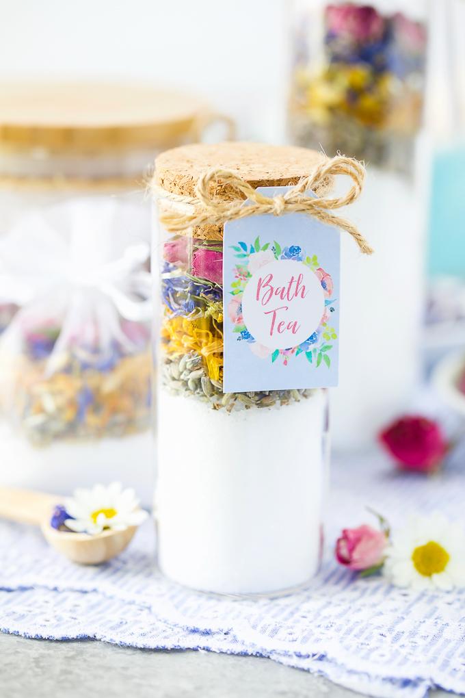 Tall corked glass tube layered with white bath salt, dried lavender, yellow blooms and pink rose petals