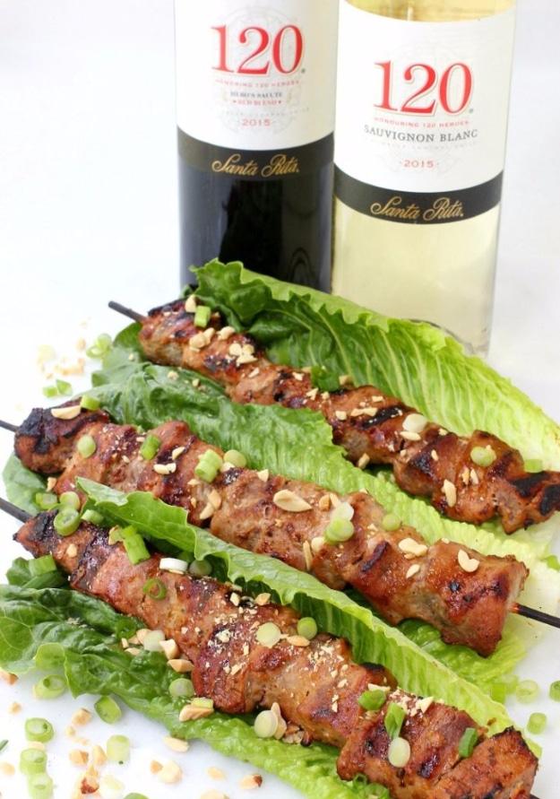 Thai coconut pork skewers off the grill served in romaine leaves with chopped peanuts and scallions for a backyard BBQ