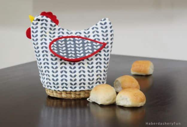 A quilted bread basket cover in warm autumn cottons, tucked into a woven basket holding dinner rolls.
