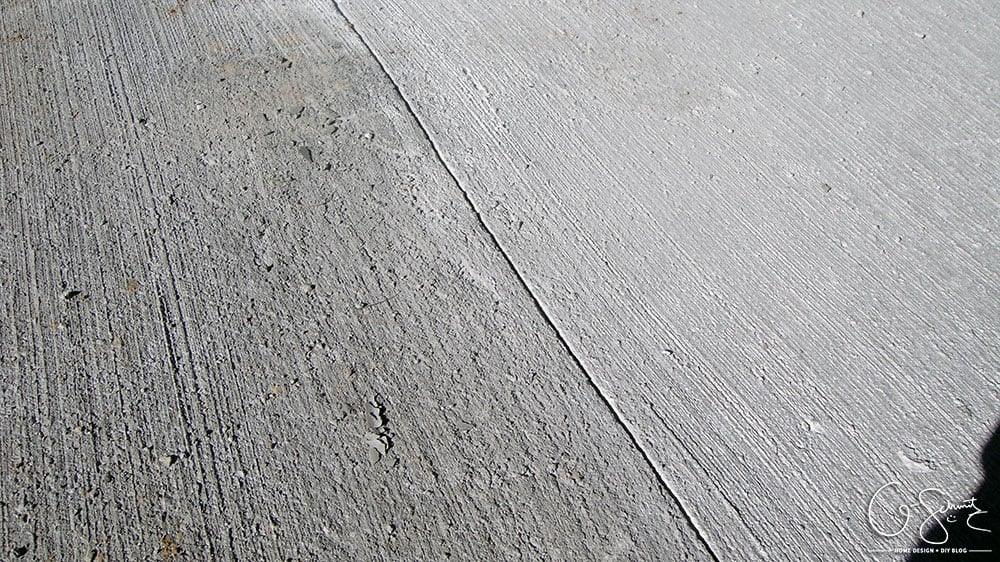 Close up of a finished poured concrete walkway showing the brushed surface texture and expansion joint
