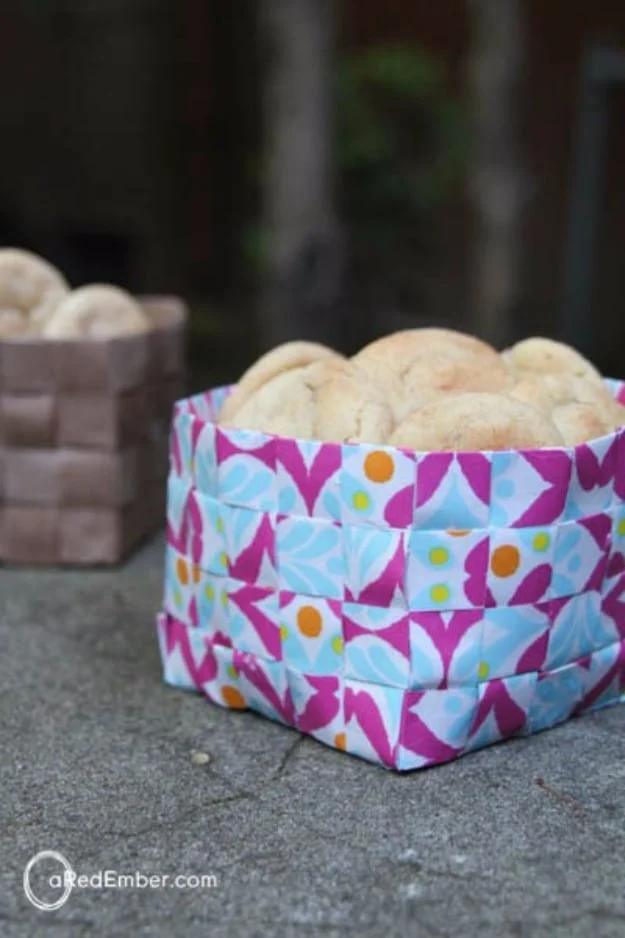 Woven wrapping paper basket in magenta and pale blue printed strips holding pale round cookies on concrete