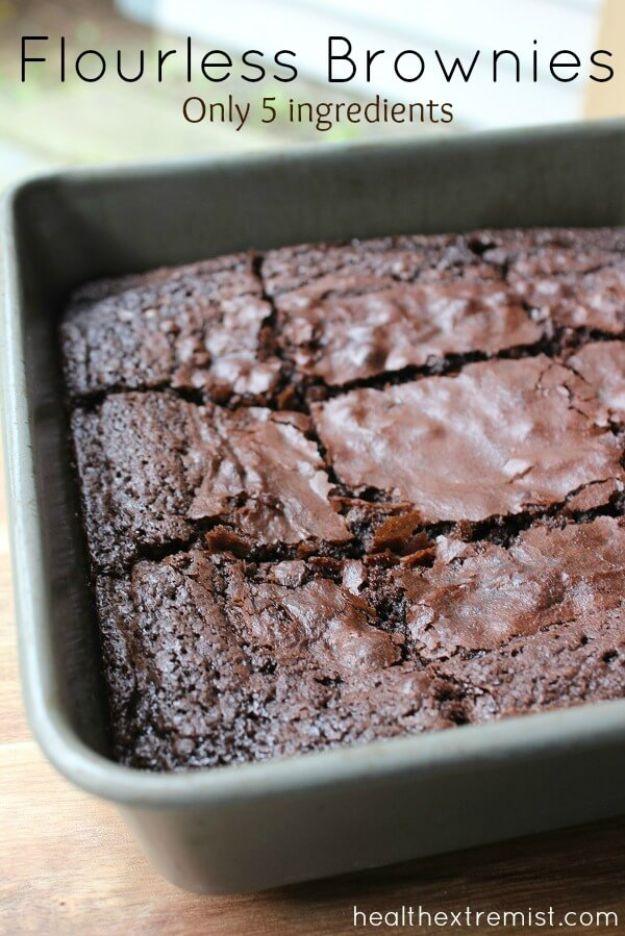 Flourless brownies baked in a dark metal pan and scored into squares with a crackled matte chocolate top