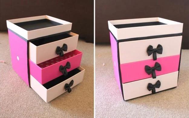 Pink and white drawer unit made from stacked boxes with black bow handles, shown with drawers open and closed